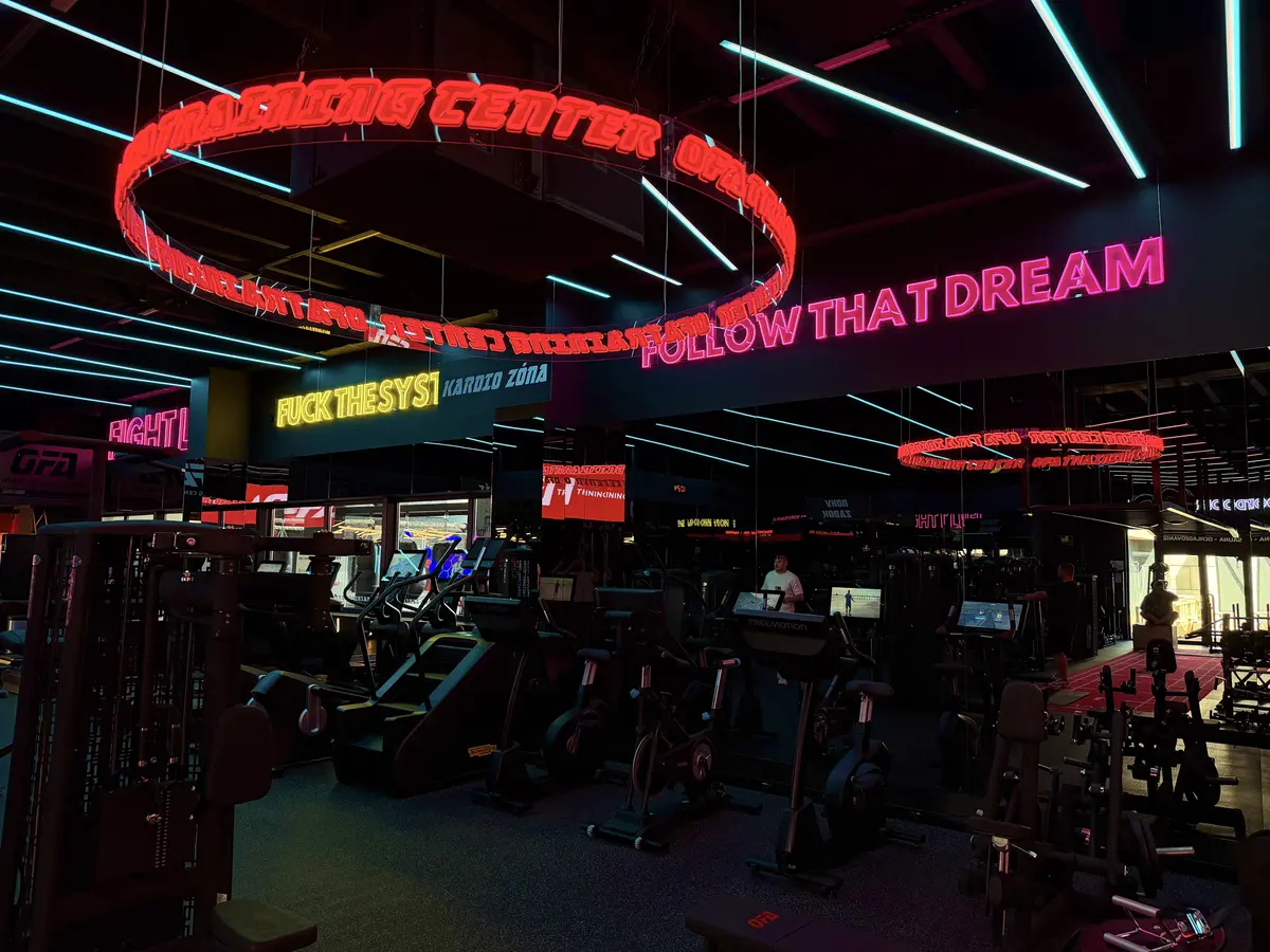 Kruhový červený neón nad kardio zónou OFA Gym — realizácia Neonworld