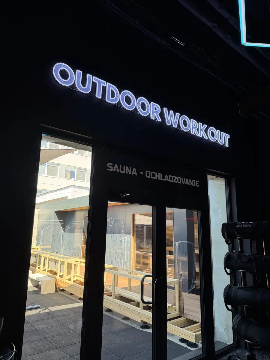 Neónový nápis Outdoor Workout nad vchodom v OFA Gym — realizácia Neonworld
