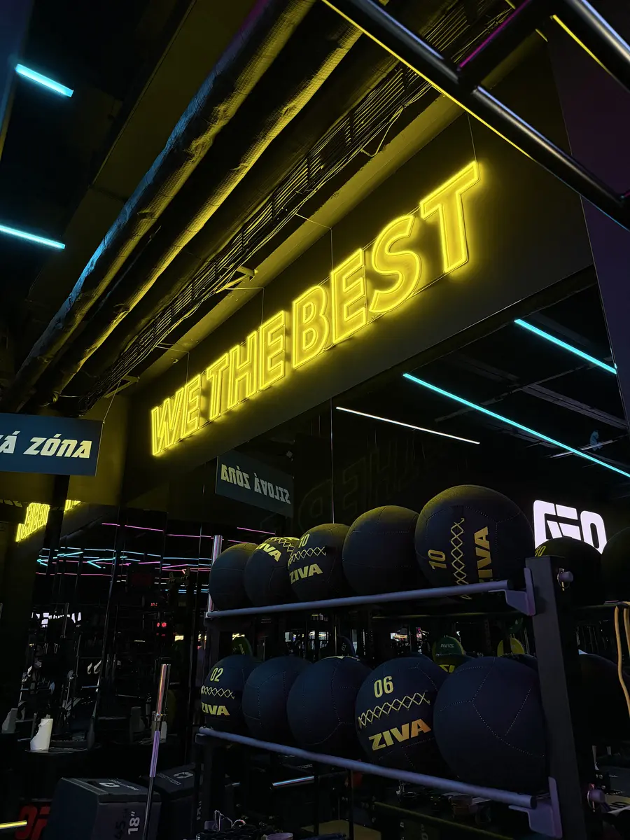 Žltý neónový nápis We The Best v OFA Gym — realizácia Neonworld