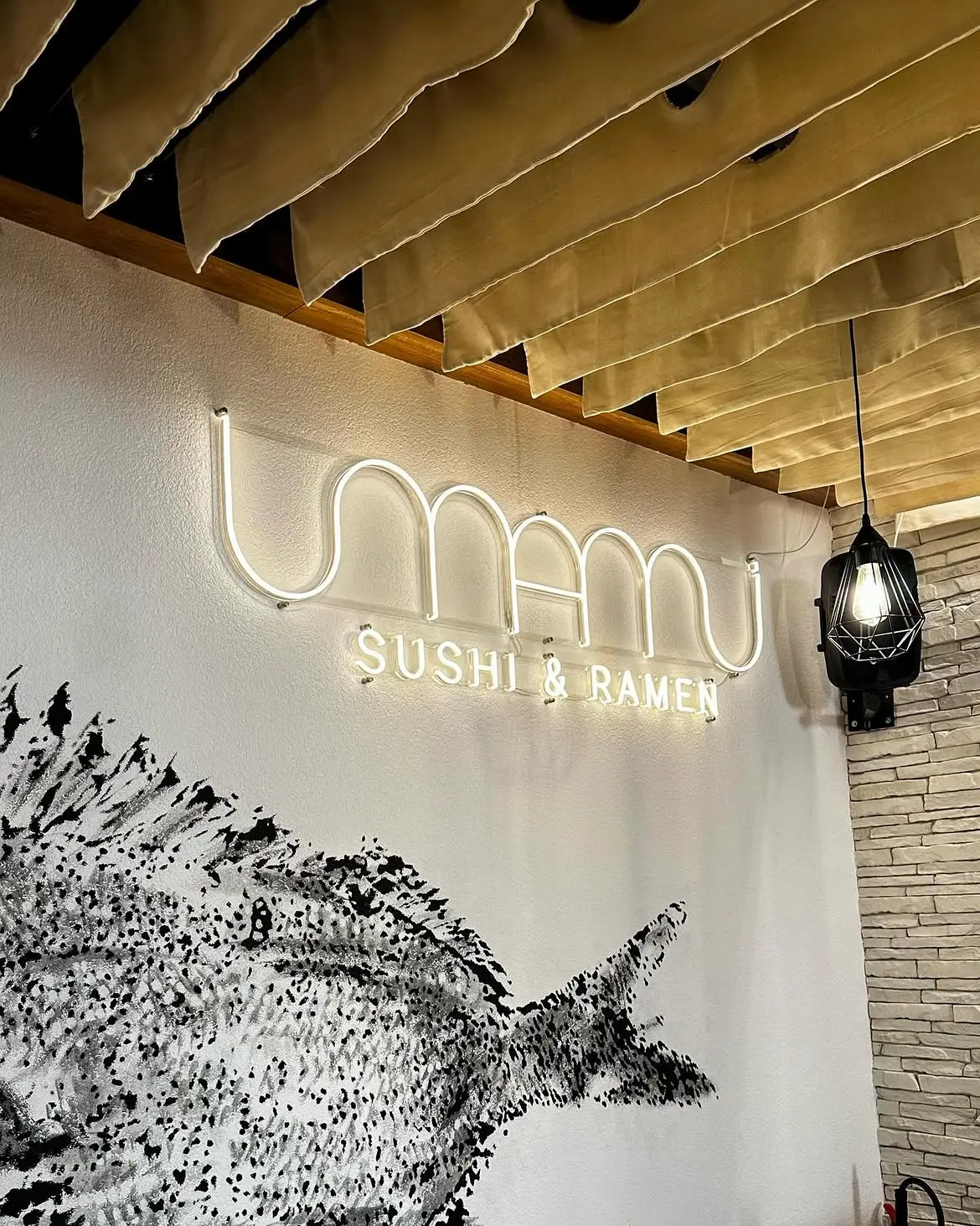 Neónový nápis Umami Sushi & Ramen v interiéri — realizácia Neonworld