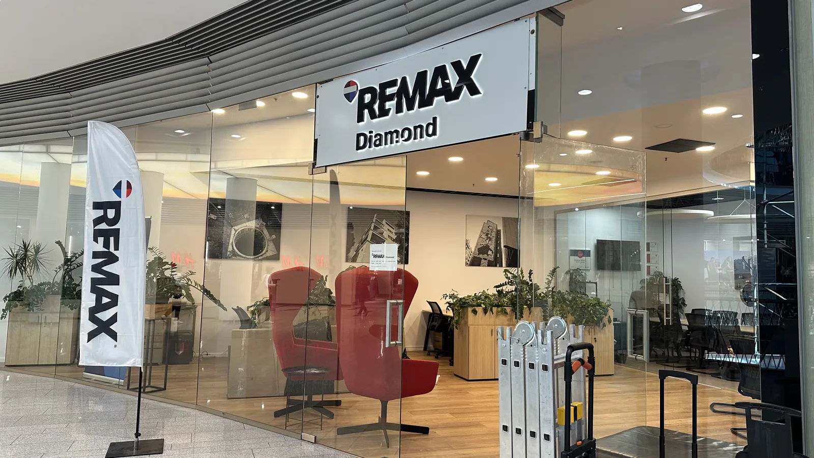 Svetelný nápis RE/MAX Diamond nad vstupom do kancelárie v obchodnom centre — realizácia Neonworld